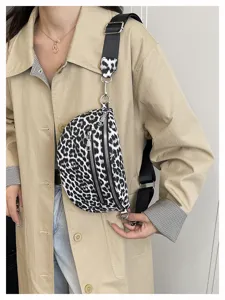 Close-up of the stylish black and white leopard print sling bag with wide strap and zippers.