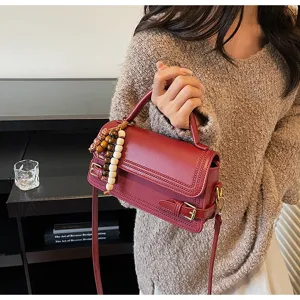 Fashion small square handbag for women, elegant red leather shoulder bag with beaded charm.