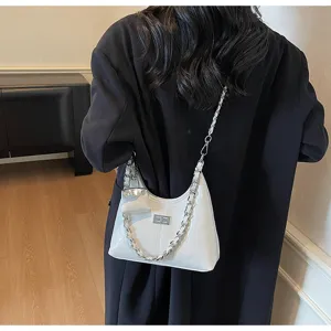 Detailed view of the stylish white patent leather shoulder bag with chain strap and mini pouch.