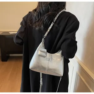 Detailed view of silver metallic shoulder bag featuring a chic chain strap and secure turn lock.