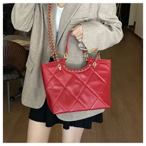 Red quilted tote bag detail shot, featuring luxury diamond pattern and gold chain strap design.