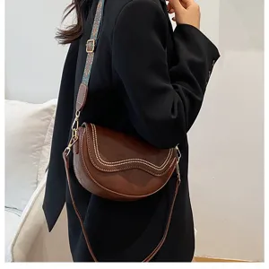 Brown saddle bag detail, vintage shoulder bag with wide strap, trendy crossbody design.