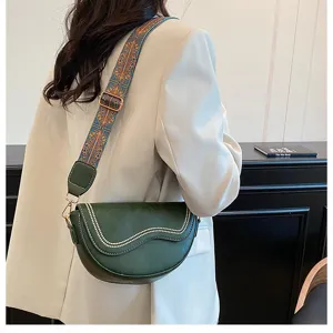 Vintage half-moon saddle bag with wide ethnic strap, stylish green crossbody shoulder bag.