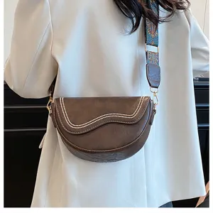 Retro brown saddle bag for women, featuring beaded wave flap and stylish wide strap detail.
