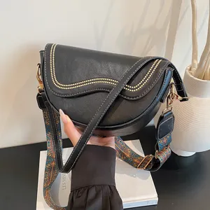Classic black saddle bag for women with stylish patterned strap and metallic studs chic fashion.