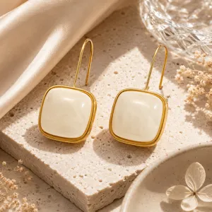 Detailaufnahme von minimalistischen quadratischen Harz-Ohrringen mit goldfarbenem Edelstahlrahmen.