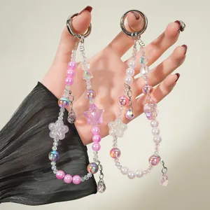 Close-up detail view of aesthetic pink beaded phone charm with star and flower pendants.