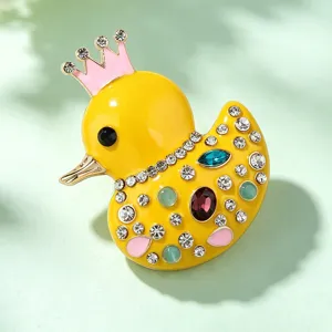 Close-up detail of cute rhinestone crown little yellow duck brooch, vibrant enamel alloy pin.