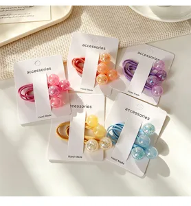 Details of cute kids hair ties with glitter balls and cards, perfect for daily cute hairstyles.