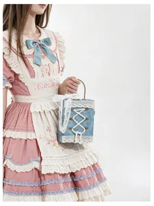 Detail shot of a cute Lolita style book shaped handbag featuring white lace and bow handle details.