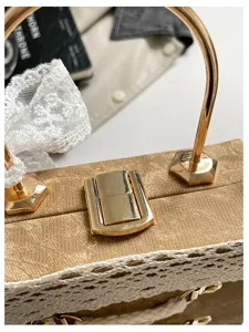 Close-up detail of a cute Lolita style lace box bag with gold metal hardware and chic handle.