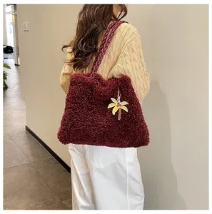 Elegante bolso tote afelpado burdeos con correa trenzada y colgante de palmera.