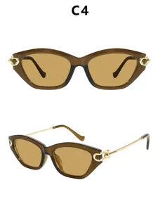 Chique cat-eye zonnebril voor dames met bruin montuur en gouden metalen veren.