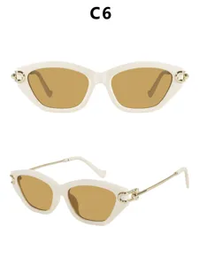 Chique dames kattenoog zonnebril met gouden metalen tempels en stijlvolle bruine glazen.