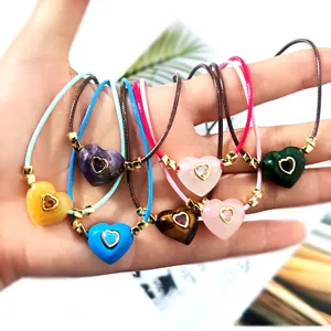 Detailed close-up showing colorful crystal heart pendant wax rope necklaces in hand display