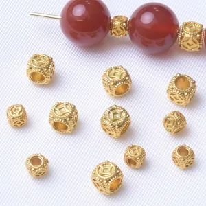 Close-up details of gold-plated copper coin spacer beads and red agate DIY bracelet parts.