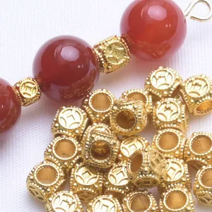 Close-up detail of ancient gold square barrel beads with copper coin pattern for DIY jewelry.