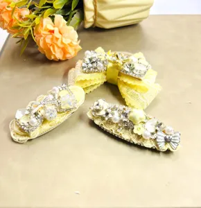 Détails en gros plan de la pince à cheveux noeud perle strass jaune avec un savoir-faire exquis.