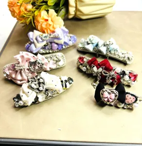 Vue détaillée de pinces à cheveux luxueuses en strass et perles avec nœuds élégants.