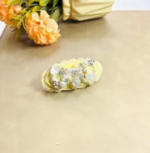 Vue détaillée de l'élégante pince à cheveux nœud perles et strass, accessoire élégant.