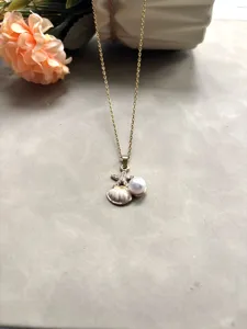 Gros plan détaillé du collier en acier titane style océan avec étoile de mer, coquillage et perle.