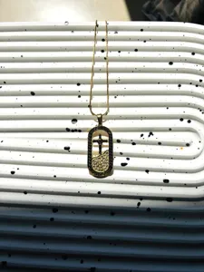 Collier avec pendentif croix plaqué or en acier titane aux détails raffinés et tendance.