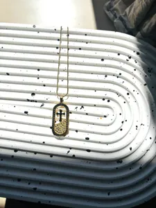 Collier pendentif croix en acier titane plaqué or avec strass et incrustation noire.