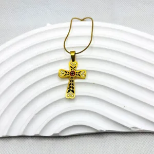 Collier pendentif croix en acier inoxydable doré avec émail noir et rouge et strass brillants.