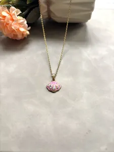 Collier de chaîne doré chic avec un pendentif coquille émaillé rose et des strass étincelants.