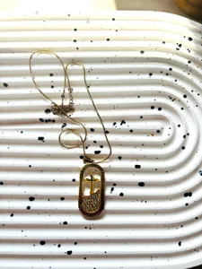 Collier pendentif croix en acier titane doré avec strass et chaîne serpent élégante.