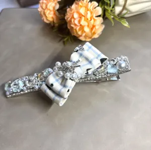 Vue détaillée de pince à cheveux strass perle de luxe avec nœud écossais pour femmes.