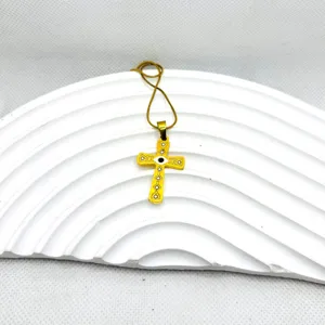 Collier croix en acier inoxydable doré avec design tendance evil eye et détails délicats.