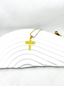 Vue détaillée d'un pendentif de collier croix en acier titane plaqué or avec des strass brillants.