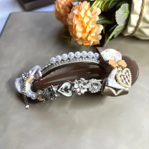 Grande pince à cheveux marron avec perles strass et nœuds en tissu pour les femmes.