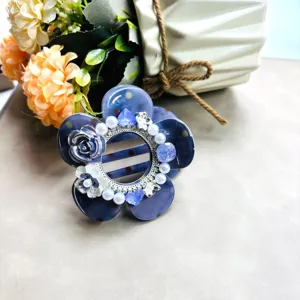 Élégante pince à cheveux fleur bleue avec perles et strass, idéale pour de superbes coiffures.