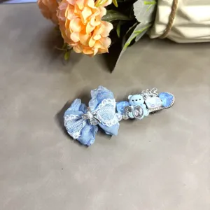 Jolie pince à cheveux nœud bleu clair avec adorable ours, dentelle et strass pour un look kawaii.