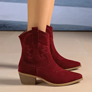 Detailed view of red suede western cowboy boots with embroidery and chunky heel design.