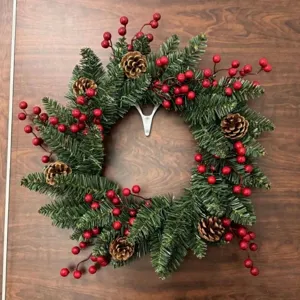 Guirnalda de Navidad artesanal con agujas de pino piñas y bayas rojas para decoración de puertas