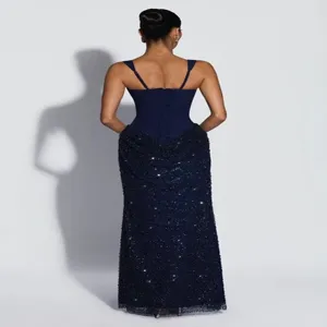 Vue arrière détaillée d'une robe de soirée bleu foncé avec laçage corset et texture brillante.