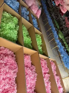 Detail view showing bulk packaged colorful preserved hydrangea flower materials in workshop boxes.