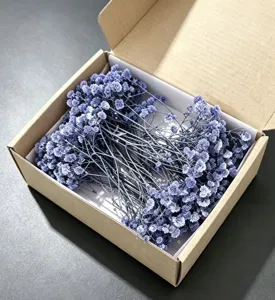 Detailed view of colorful preserved gypsophila dried flowers in a gift box for DIY craft decor.