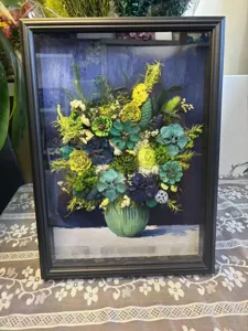 Primer plano de arte floral seco enmarcado en 3D, mostrando detalles florales preservados.
