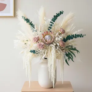 Dried flower arrangement with protea and pampas grass in white ceramic vase for home decor.