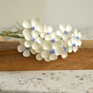 Dettaglio fiore artificiale fatto a mano con petali bianchi per la decorazione domestica.