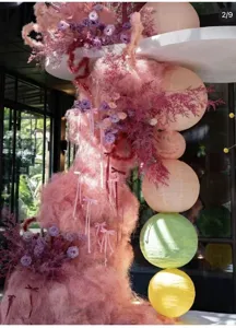 Pink sisal fiber packaging filler detail showing decorative dried flowers and paper lanterns.