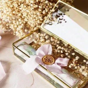 Gold rimmed glass box with dried baby breath flowers and pink ribbon for wedding home decor.