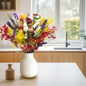 Detailed view of colorful dried flower bouquet arranged in a white ceramic vase for home decor.