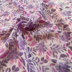 Floral print scarf fabric detail showing purple and pink leaves with gold accents.