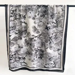 Vista dettagliata di una sciarpa con stampa floreale in bianco e nero elegante.