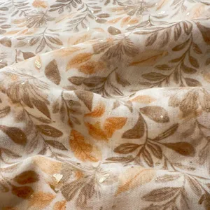 Cotton linen leaf print scarf detail view, elegant gold foil shimmering summer shawl fabric.